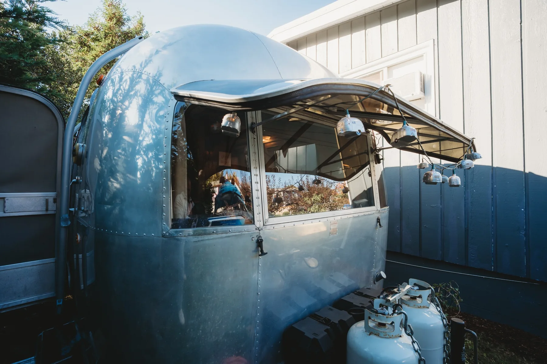 Caravel side exterior with classic silver Airstream shell and large open awning-style window