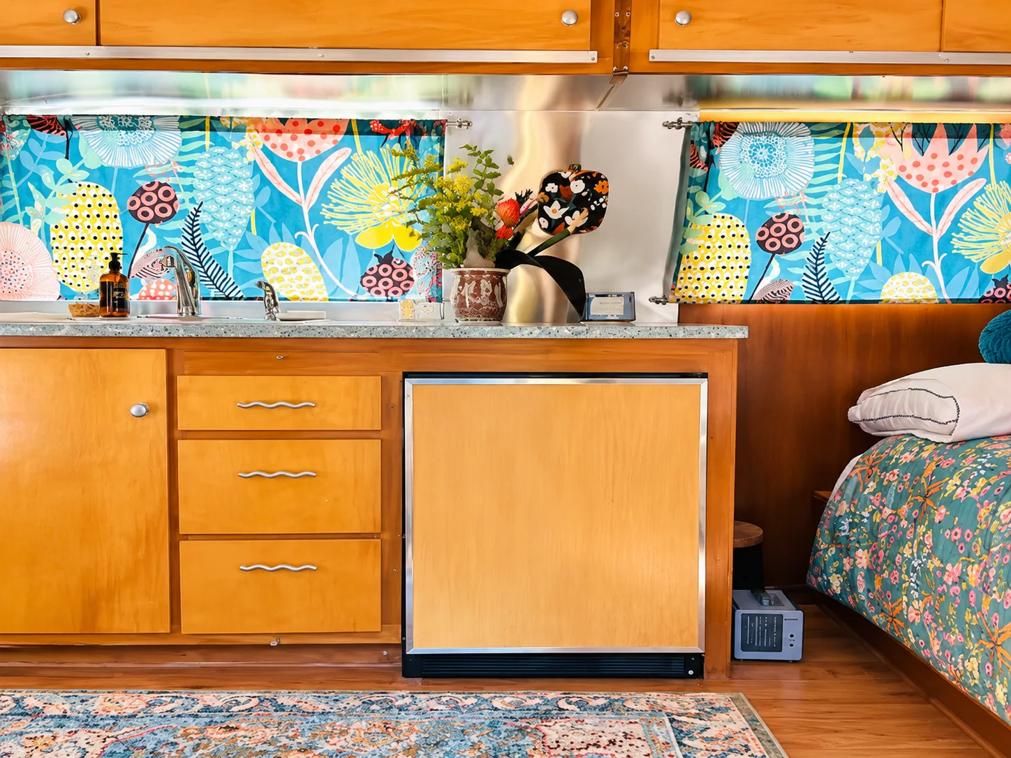 Safari honey-toned kitchen cabinets with colorful patterned window curtains